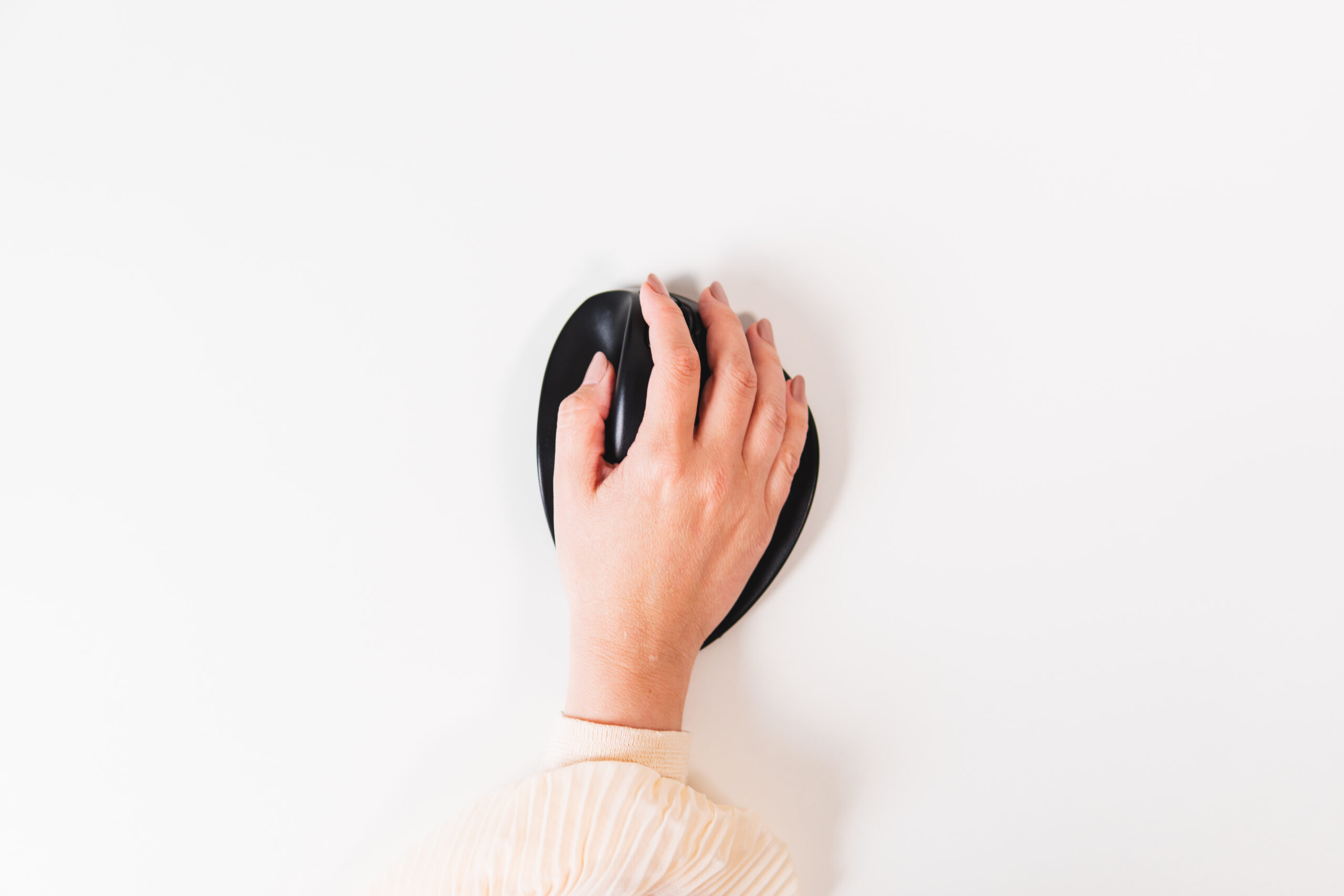 Hand ligt op zwarte ergonomische HandShoeMouse van BakkerElkhuizen, met gebogen vorm en geïntegreerde knoppen